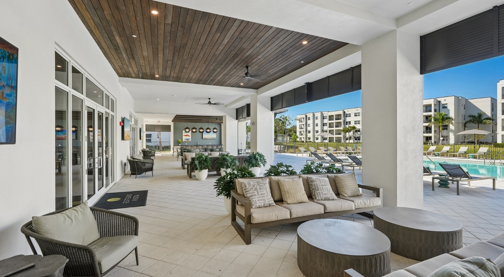Shaded outdoor lounge at Estero Vista featuring comfortable seating and views of the resort-style swimming pool.